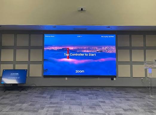 LED stena v zasadačke s úvodnou obrazovkou Zoom Rooms a akustickými panelmi na stene